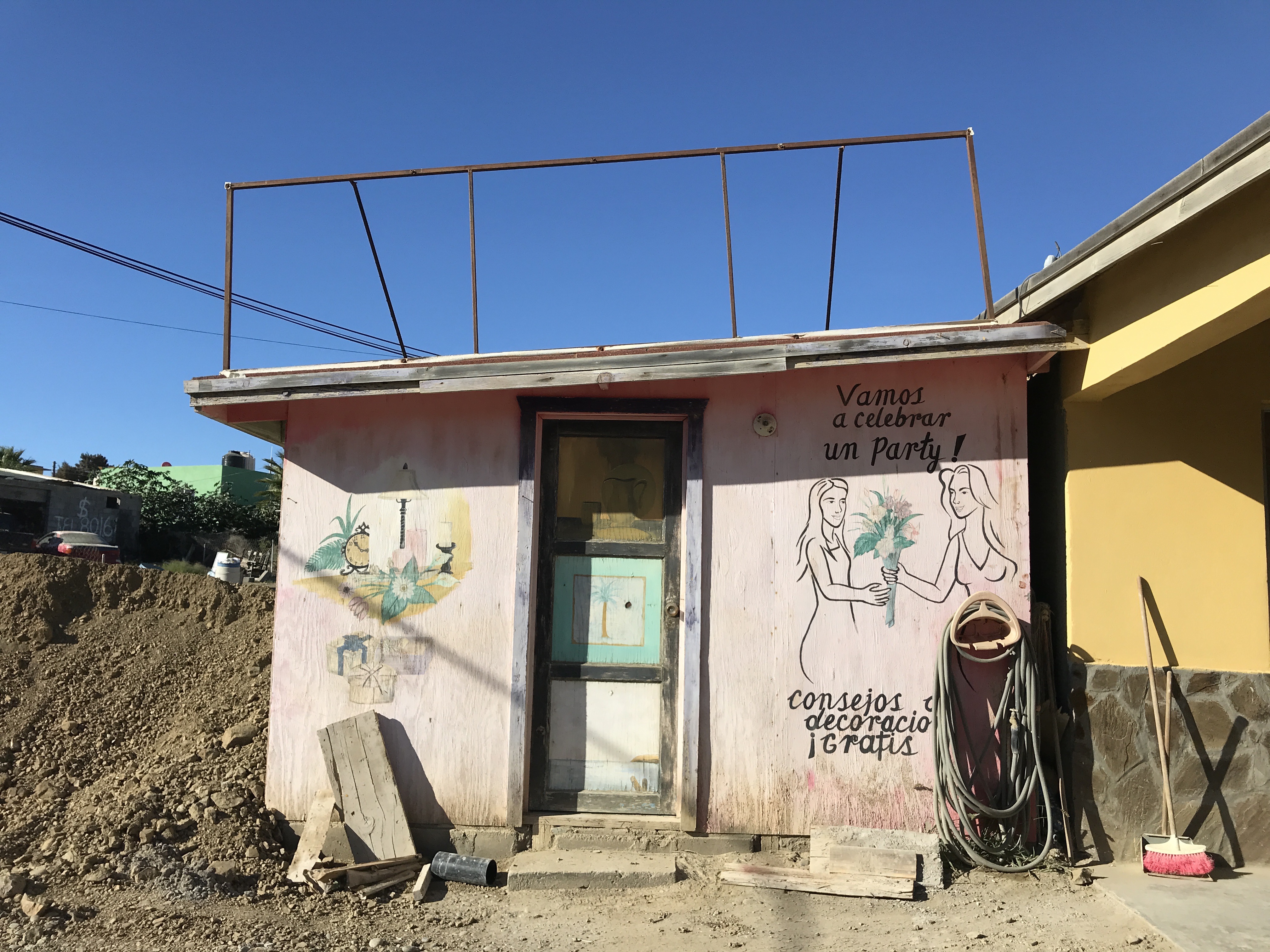 A hand painted ad for a flower shop where one woman gives another woman a colorful bouquet. It says "vamos a celebrar un party!"
